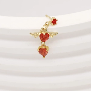 Macro shot of a winged heart pendant nose stud with red gemstone and golden finish
