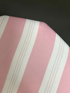 Nahaufnahme der rosa-weiß gestreiften Stoffstruktur mit feinen Webdetails des Hemdes