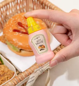Miniature pink condiment bottle toy with Tasty Soy Sauce label held in hand