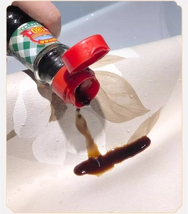Waterproof cream floral leather placemat showing oil-resistant surface with soy sauce drop