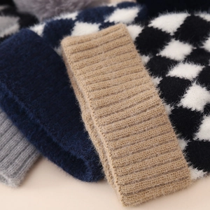 Close-up of thick knitted baby hats showing soft faux mink texture and checkered patterns