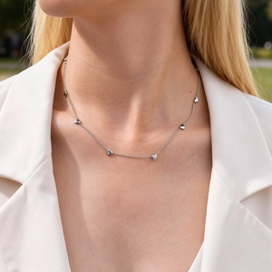 Minimalist silver heart choker necklace featuring small heart pendants on a delicate chain
