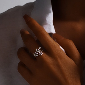 Macro detail of silver leaf and pink floral ring with marquise zircons on finger