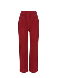 Detail view of deep red ribbed knit trousers with an elastic waistband and straight leg cut