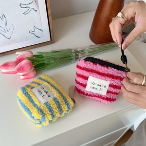 Detail view of colorful striped plush mini bags with soft texture and black zipper closure