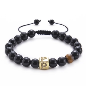 Macro shot of black agate beads with tiger eye stone and gold zircon letter P charm
