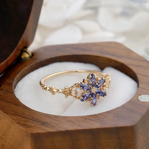 Macro shot of vintage floral ring with purple marquise stones in a walnut wood box