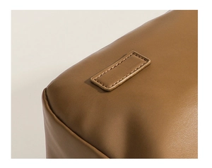 Close-up of brown leather texture and detailed double-stitched seams on the shoulder bag