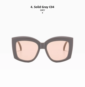 Detail view of solid grey oversized square sunglasses with thick frames and light peach lenses