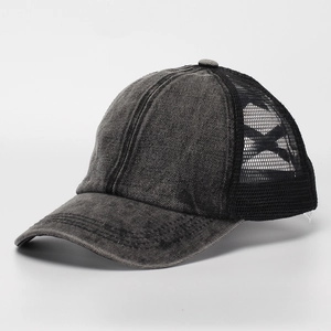 Detail of washed denim baseball cap with mesh back and distressed frayed brim design