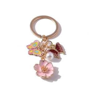 Floral pearl butterfly keychain with pink flower and colorful enamel charms on gold metal
