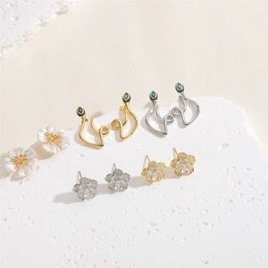 Macro detail of camellia and snake earrings with green zircons and pearly petals