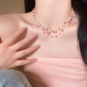 Gros plan sur le collier multicouche en pierres roses et perles sur le cou