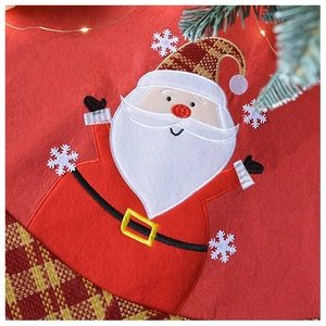 Close-up of Santa Claus applique and plaid border on red linen Christmas tree skirt
