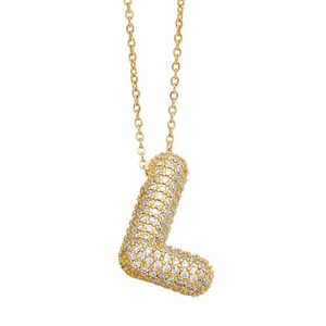Macro shot of gold balloon-style letter L pendant with pavé crystal zircon settings