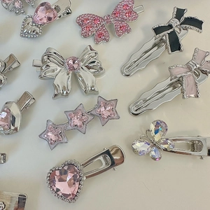 Detail of silver alloy hair clips set featuring pink rhinestones and heart star shapes