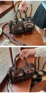 Detail of dark brown glossy saddle bag with front pockets and adjustable strap