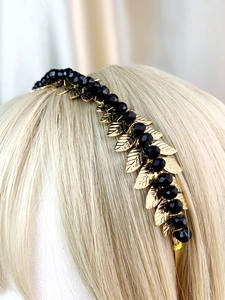 Detailed view of handmade golden leaf headband with faceted black crystal beads on a model