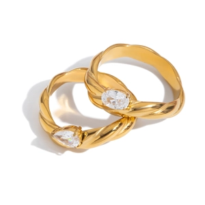 Golden titanium steel twisted rings featuring pear and oval zircon stones on white background