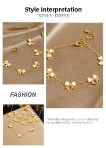 Détail de la parure bijoux nœud doré avec émail blanc posée sur un tissu en satin champagne