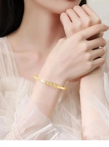 Close-up of golden hammered bracelet featuring a crushed ice texture on a female wrist