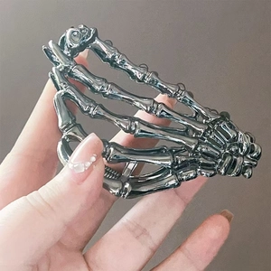 Detailed close-up showing the metallic skeleton hand claw clip with a reflective chrome finish