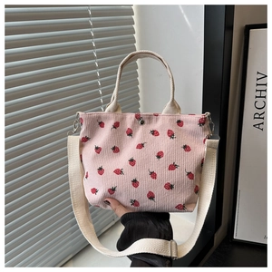 Detail of pink corduroy tote bag with red strawberry pattern and secure magnetic closure