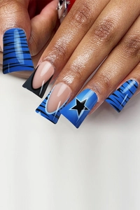 Detail of long coffin nails with blue tiger stripes and black star patterns
