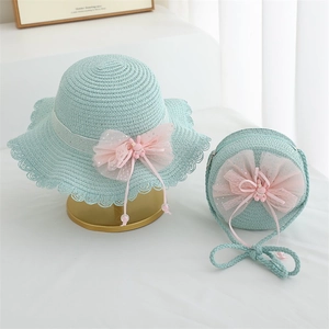 Detail of light blue straw sun hat and matching bag set with pink lace bow and bunny