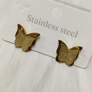 Detailed close-up of golden butterfly earrings featuring matte and polished layers