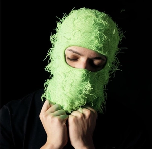 Detail of lime green distressed knit balaclava showing frayed texture and street style