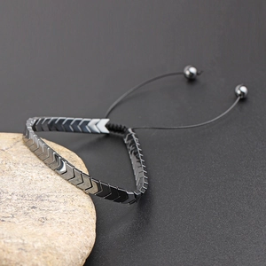 Detail view of arrow-shaped hematite beads on a black adjustable woven bracelet