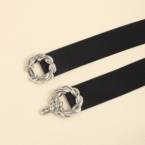 Detail view of two black elastic waist belts with silver twist and T-bar metal buckles