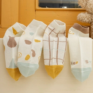 Detail of four pairs of breathable mesh socks with cute geometric and smile patterns