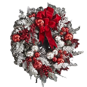 Christmas wreath with red velvet bow, silver ornaments, and flocked pine needles on white background