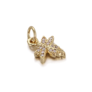 Detail shot of a gold leaf pendant featuring sparkling cubic zirconia and a sturdy jump ring