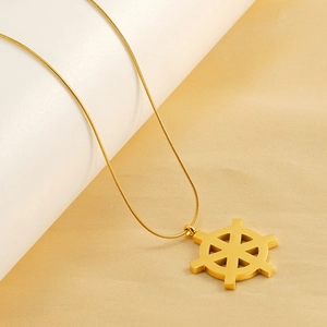 Détail macro du pendentif boussole doré sur fond élégant en tissu de soie jaune