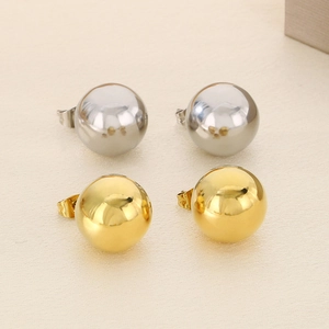 Polished 18K gold and silver stainless steel ball stud earrings set in a macro view
