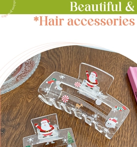 Close-up of clear acrylic Christmas hair claw clips with Santa and snowflake prints