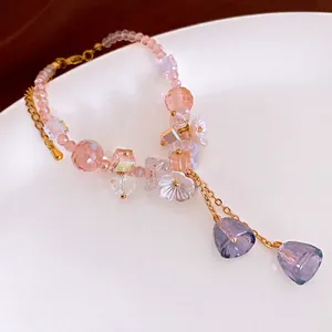 Elegant beaded bracelet with pink frosted beads, floral charms and golden chain detail