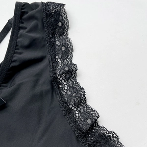 Dettaglio della sexy pizzo nero e dei cinturini incrociati sul perizoma a vita bassa