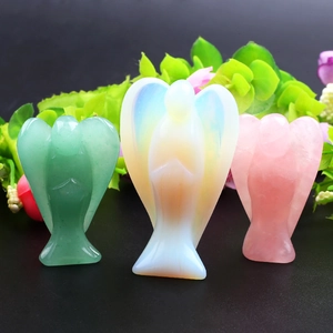 Detailed view of three carved crystal angels in rose quartz, opalite and aventurine