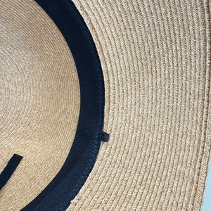 Detailed macro view of woven straw sun hat interior with black sweatband and fine stitching
