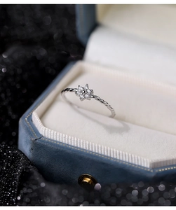 Detailed close-up of S925 silver flower ring with zircon stones on blue velvet padding
