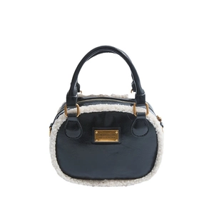 Chic black and beige leather pillow bag with plush faux shearling trim and gold hardware