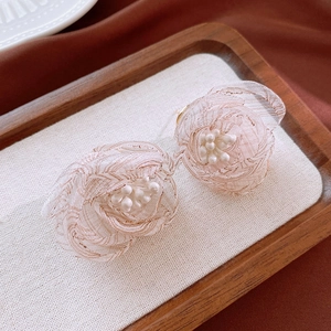Detailed close-up of handmade floral earrings with pink mesh petals and small white pearls