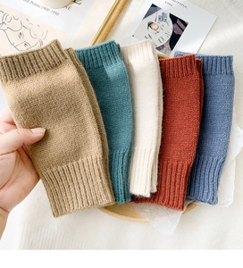 Detail of knitted fingerless gloves in five colors with soft ribbed cuffs and thick texture