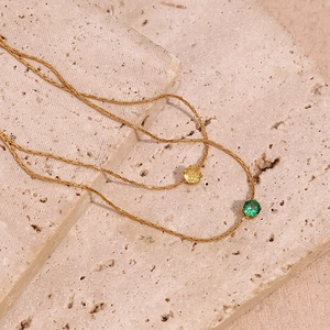 Detail of 18K gold plated thin chain necklaces with green and yellow zircon pendants