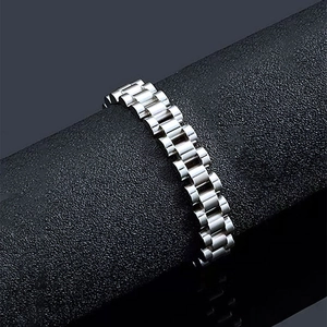 Macro view of silver stainless steel watch-style link bracelet on a display stand