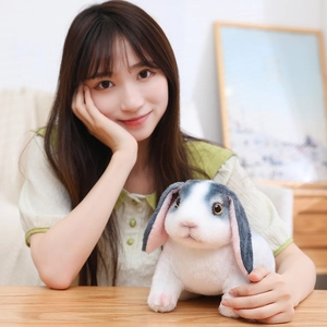 Gros plan du lapin en peluche réaliste avec fourrure grise et blanche sur table en bois